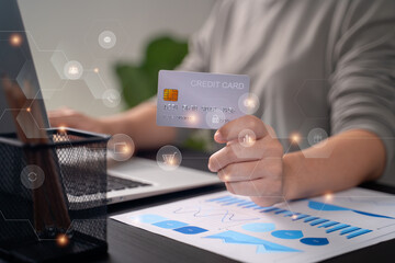 Close up shot of females  hands holding credit card typing message on laptop for shopping online with technology icons.
