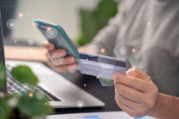 Close up shot of females hands holding credit card typing message on smart phone with technology icons for shopping online.