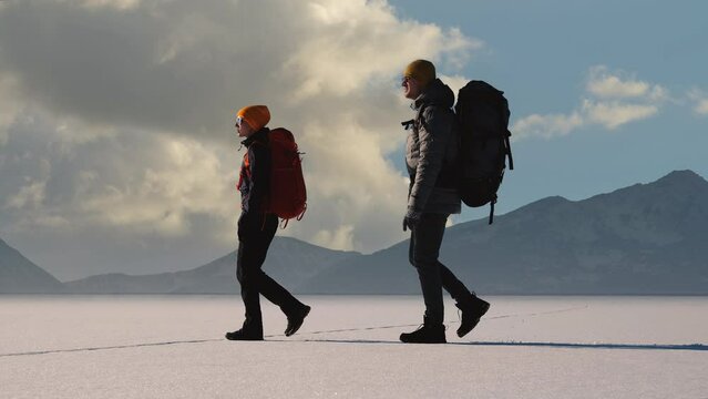 The two travelers walking on a mountains background. slow motion