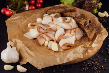 Ukrainian traditional food - sliced smoked lard on cutting board with garlic