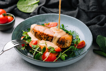Grilled salmon with vegetables and sour cream sauce