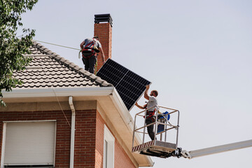 Technicians installing solar panels on rooftop