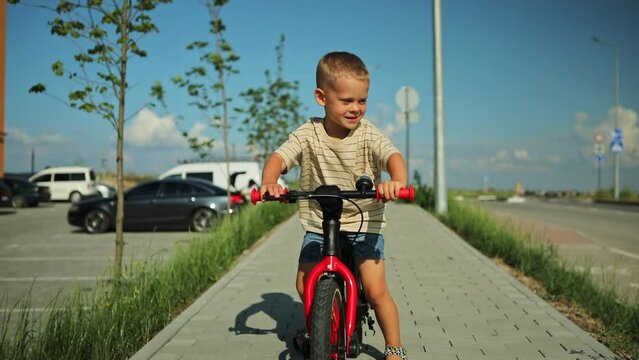 handsome little boy riding a bicycle in the park