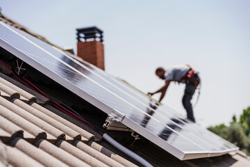Electrician installing solar panels on roof