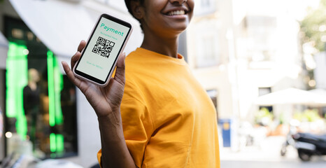 Smiling woman showing smart phone with QR code