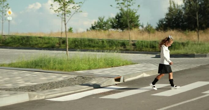 schoolgirl crosses the road at a pedestrian crossing