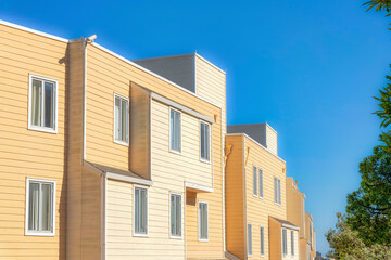 Apartment building exterior with yellow wood lap siding in San Francisco, California