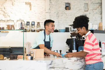 Smiling man serving coffee to customer in cafe