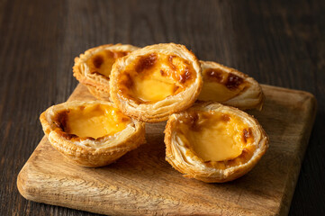 Pastel de nata, traditional Portuguese egg tart on the wooden backgrund.Close up