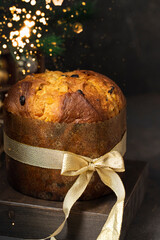 Panettone with gold bow with Christmas tree branch. Italian  large fruity enriched sweet bread...