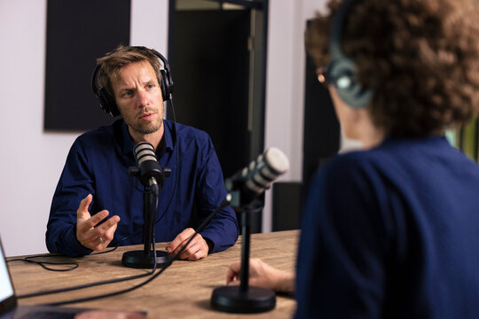 Guest wearing headset talking with presenter in radio station