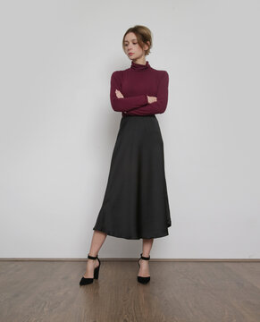 Serie of studio photos of young female model wearing purple turtleneck with simple midi skirt. Comfortable and elegant everyday fashion.