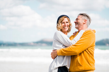 Happy mature couple having fun at beach on vacation