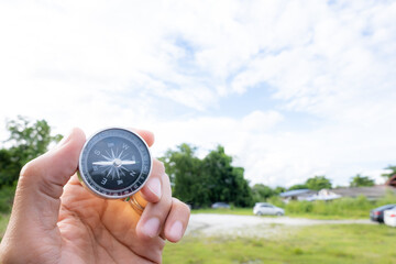 holding compass on tree mountain and sea blurry background. Using wallpaper or background travel or navigator image.