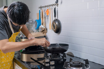 Asian chef fried eggs on pan to thai food in kitchen on gas stove The oil in pan boiling.Eggs and pork cooked. before serving to happy family to eat togetherness in home