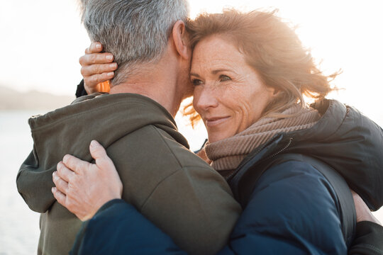 Happy Mature Woman Hugging Man On Sunny Day