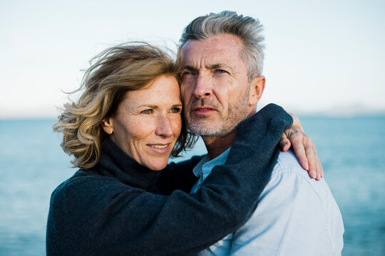 Mature couple in front of sea on sunny day