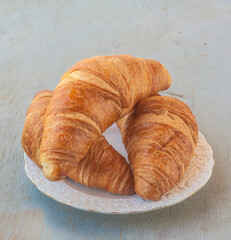 Three croissants  on a white retro plate.