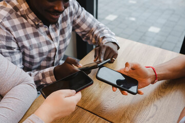 Friends sharing data through smart phones at cafe