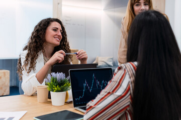 Businesswomen meeting on office with chart on laptop display