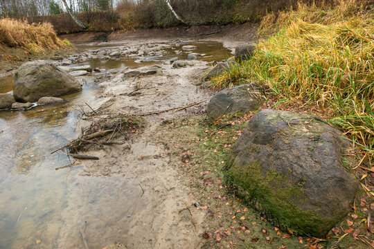 Small parched forest river in an autumn evening