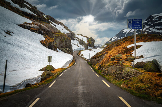 Norway, Rogaland, Sauda, Road 520 stretching between snow-covered hills