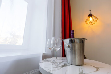 two glass goblets and champagne in a bucket on the table. dating preparation. Good way to pass the evening