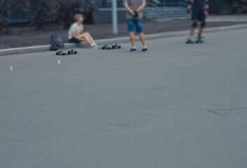 Blurred image of young people riding skateboards in summer park