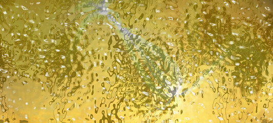 Transparent colored glass. Golden color rippled background. Abstract liquid metal texture.