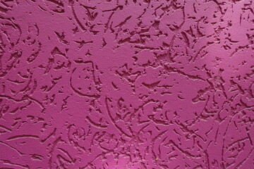 Surface of fuchsia colored worm stucco wall finish