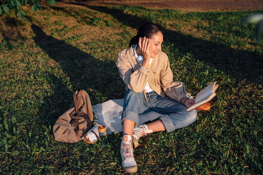Smiling woman reading book at park
