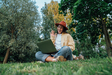 Smiling woman talking on video call over laptop at park