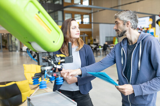 Technicians discussing technical solutions looking at industrial robot