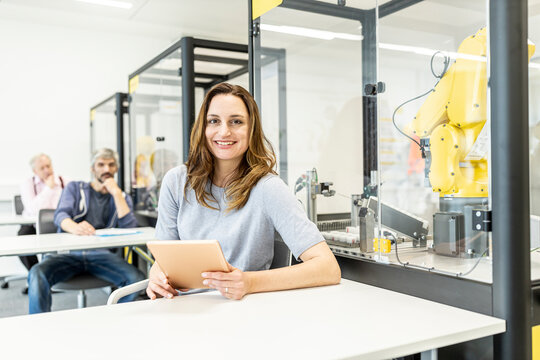 Woman working in robotic factory using digital tablet