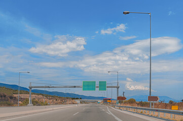 Fototapeta na wymiar Clear high way with green road sign and blue beautiful cloudy sky
