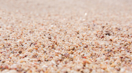 Close up of macro shot beach small colorful stones and wave in the background