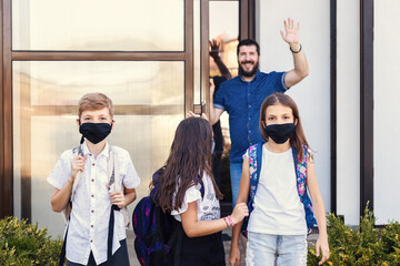 School kids with masks and backpacks leaving home to return back to school - 521964880