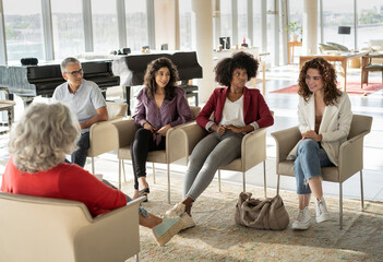 Smiling young businesswoman discussing strategy with colleagues in brainstorming session at office