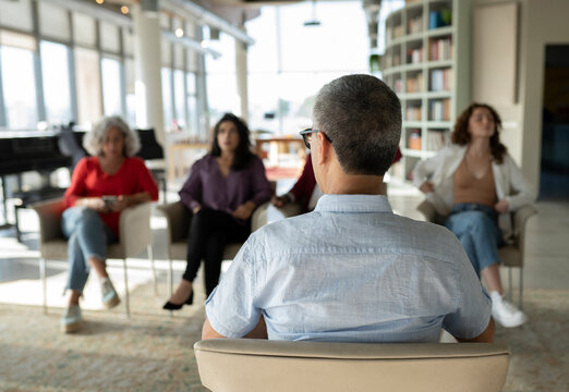 Mature Businessman Sharing Strategy With Colleagues In Brainstorming Session At Office