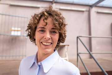 Happy mature real estate agent with brown curly hair