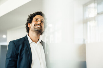 Businessman in smart casual day dreaming at workplace