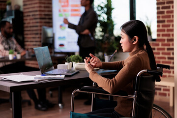 Worker with chronic impairment using remote teleconference chat on laptop, sitting in wheelchair. Female employee with disability meeting on online videoconference call, telework.
