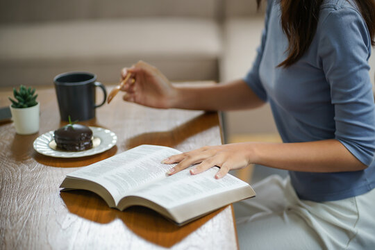 Happy woman reading a book and relaxing comfortably. Female hands with book at home Study Concept reading book