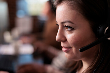 Telecommunication receptionist answering client call on headset, talking to people on remote...