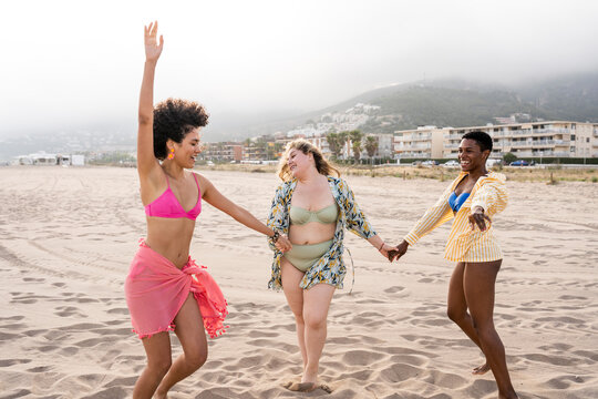 Multiracial women dancing at beach