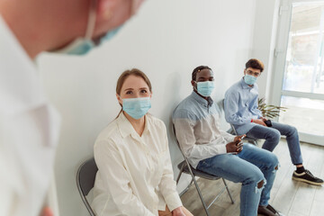 Patients wearing face masks waiting at clinic