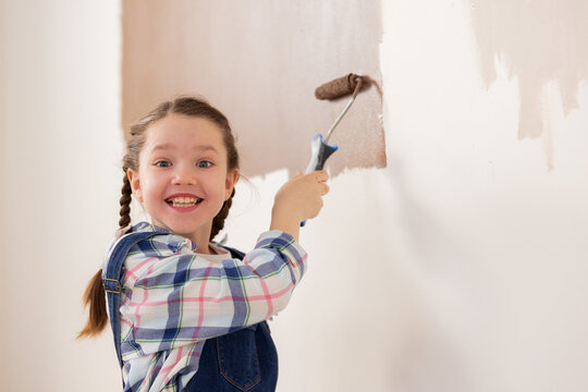 A girl with a wide smile, just delighted that her parents allowed her to paint the walls on her own in her room, which is undergoing renovation.