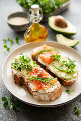 Sandwiches with salted salmon,  avocado and microgreens.