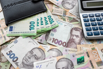 exchange concept euro bills in purse with calculator lying on euro banknotes background