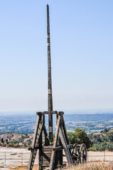 front view, far distance of a mid evil, 1500's, wooden, stone thrower, on wheels, in an open field of Provence, France 